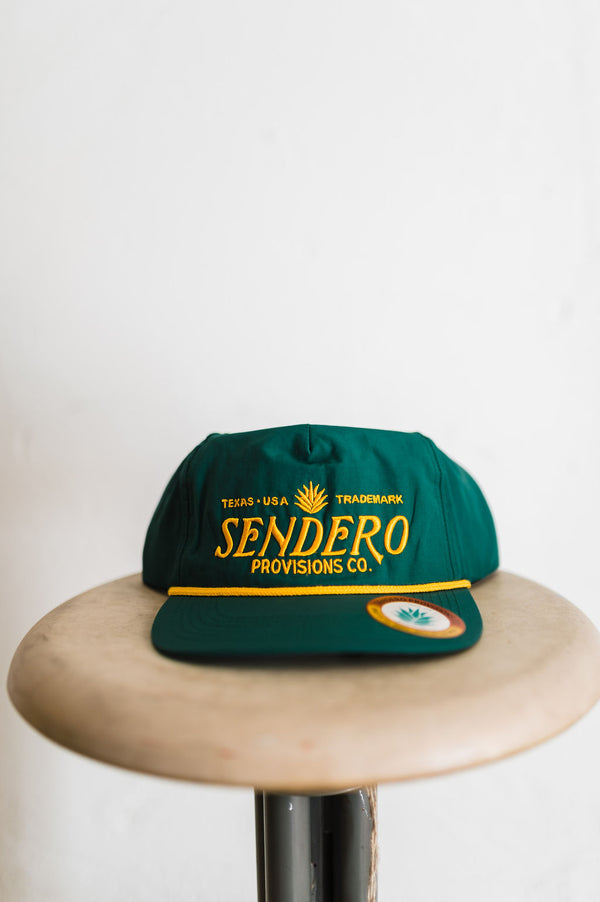 sendero logo | green + gold hat