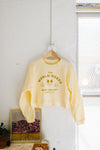 the world needs | crop raglan fleece sweatshirt french vanilla