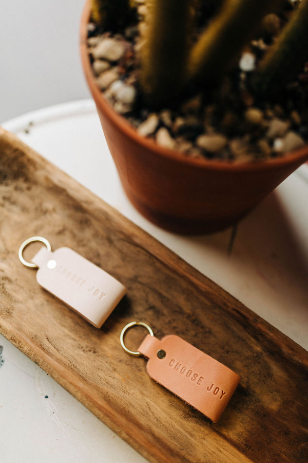 the design: choose joy. the material: leather. hand stamped by lost penguin leather. made in texas. key fobs are fun but leather key fobs are the most fun.Ramble & Co. is a family owned business. Shop at shop.rambleandcompany.com or visit our store in Wichita Falls, Texas || small batch/ hand printed tees + fine art prints | your source of encouragement + inspiration.