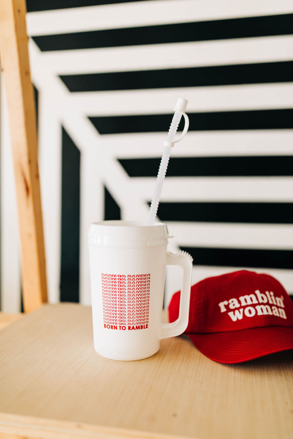 22 oz double insulated, white cup with born to ramble written in a red design | dishwasher safe | includes lid and straw || you can shop now at  shop.rambleandcompany.com or visit our storefront in downtown Wichita Falls, Texas || small batch + hand printed tees | home goods | paper goods | gifts + more