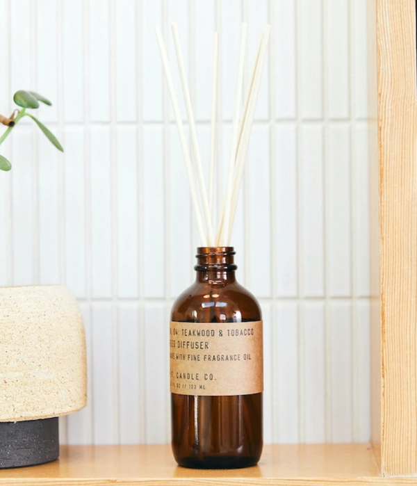 3.5 fl oz glass bottle reed diffuser that includes rattan reeds and made with naturally-derived and man-made fragrance oils | scent is a  blend of leather, teak, and orange | made by PF Candle Co. || you can shop now at shop.rambleandcompany.com or visit our storefront in downtown Wichita Falls, Texas || small batch + hand printed tees | home goods | paper goods | gifts + more