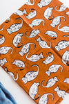 Burnt orange bandana with white kitties design by Hemlock Goods | you can shop now at  shop.rambleandcompany.com or visit our storefront in downtown Wichita Falls, Texas || small batch + hand printed tees | home goods | paper goods | gifts + more