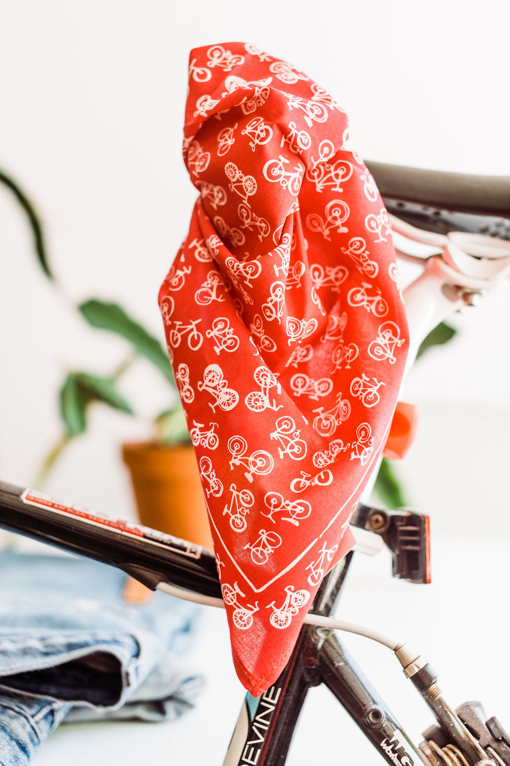 Red bandana with white bicycles design by Hemlock Goods | you can shop now at  shop.rambleandcompany.com or visit our storefront in downtown Wichita Falls, Texas || small batch + hand printed tees | home goods | paper goods | gifts + more