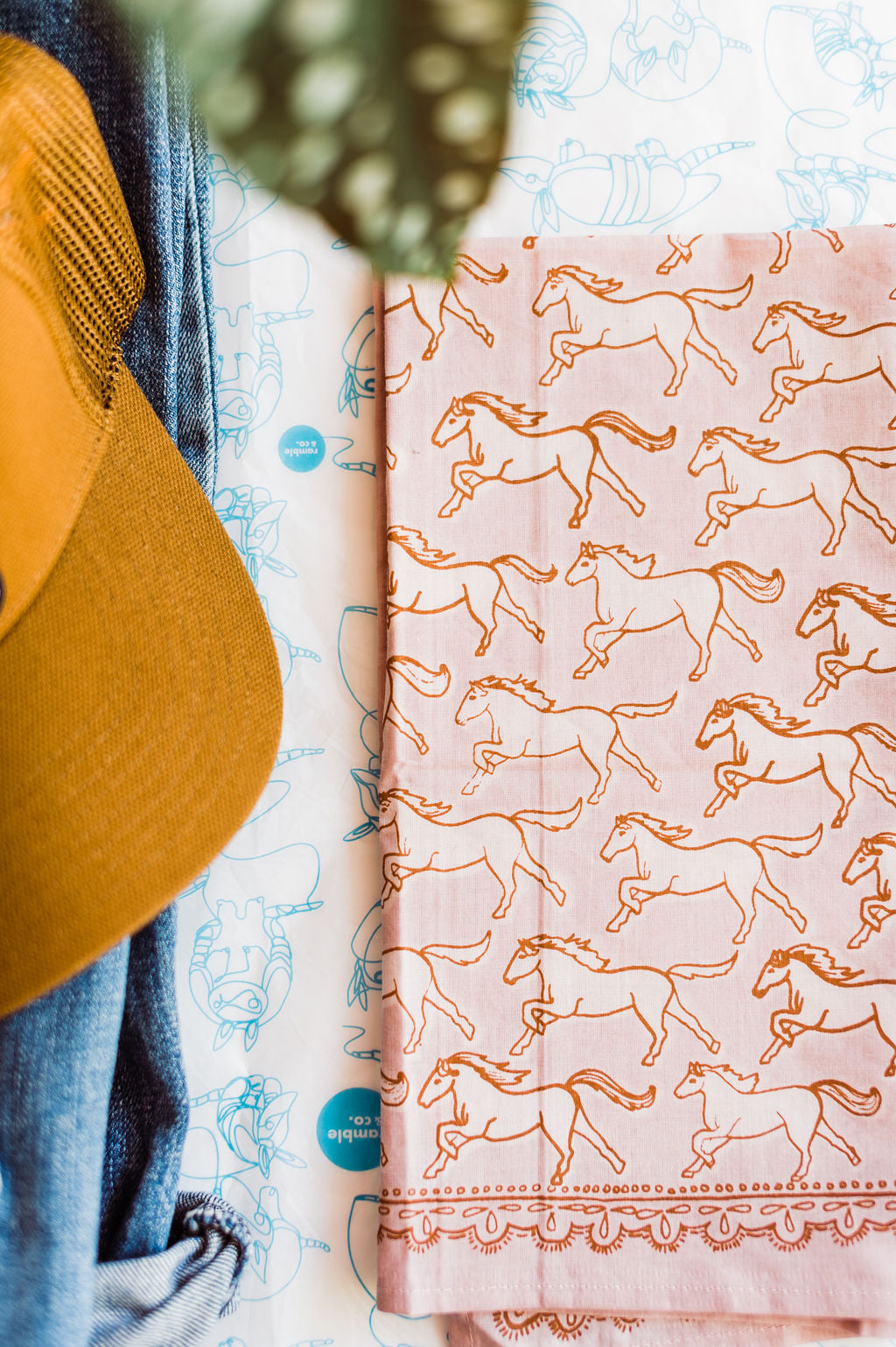 Pink bandana with brown outlined horses design by Hemlock Goods | you can shop now at  shop.rambleandcompany.com or visit our storefront in downtown Wichita Falls, Texas || small batch + hand printed tees | home goods | paper goods | gifts + more