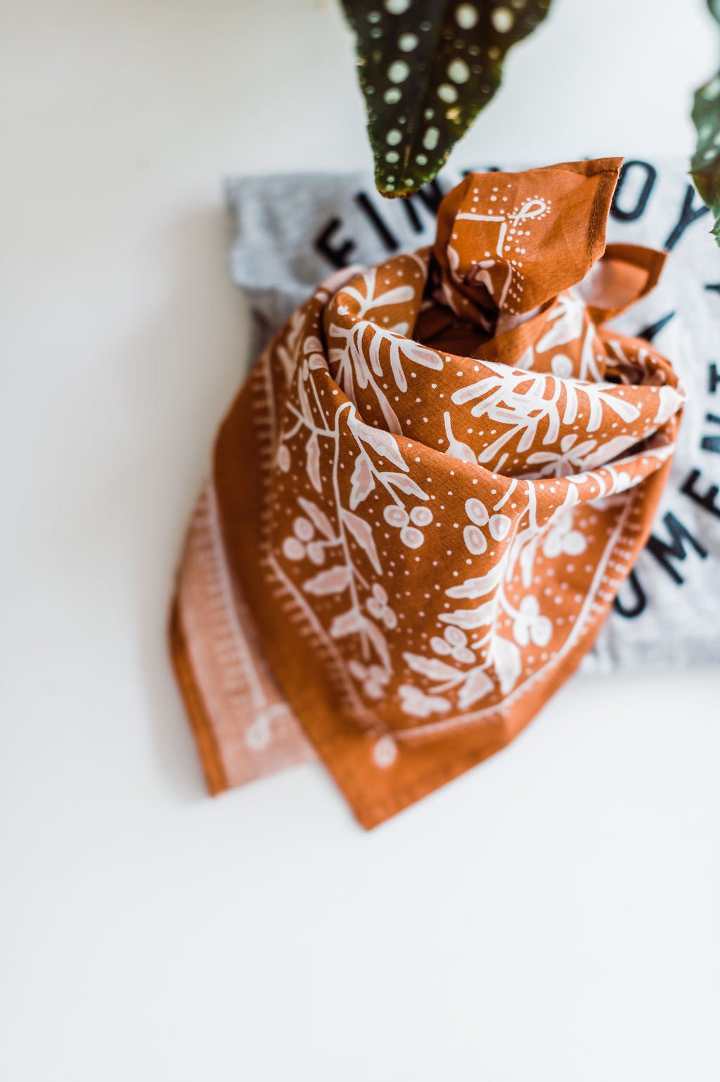 Copper bandana with light pink flowers design by Hemlock Goods | you can shop now at  shop.rambleandcompany.com or visit our storefront in downtown Wichita Falls, Texas || small batch + hand printed tees | home goods | paper goods | gifts + more