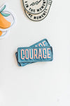Iron on, blue patch with Courage written in bold pink letters by Ramble & Company  | you can shop now at  shop.rambleandcompany.com or visit our storefront in downtown Wichita Falls, Texas || small batch + hand printed tees | home goods | paper goods | gifts + more